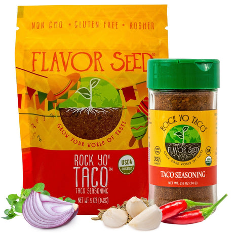 A Flavor Seed Rock Yo' Taco organic taco seasoning 5 oz pouch and 2.6 oz jar side by side on a white background, with half a red onion, fresh oregano, garlic cloves, fennel seeds and red chillies in front of them.