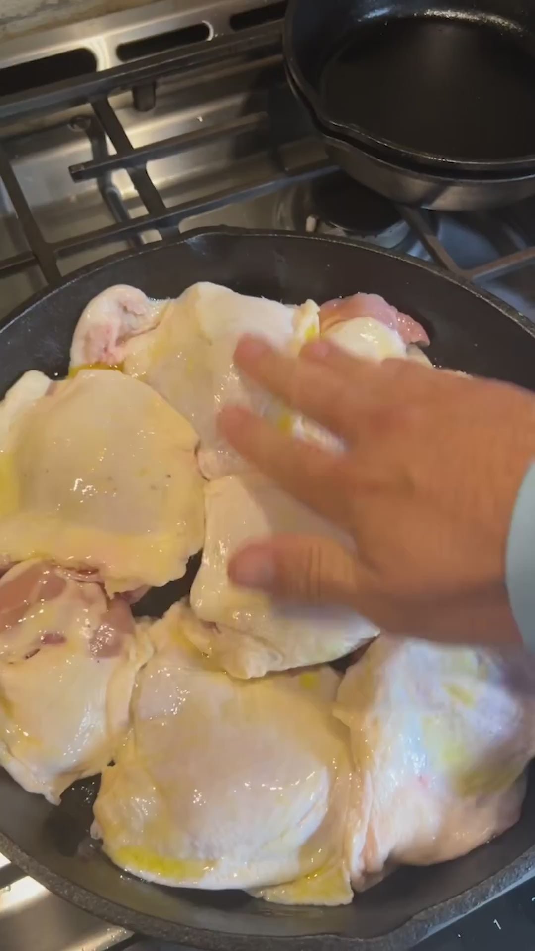 Anything With Wings organic poultry seasoning sprinkled on chicken thighs in a cast iron skillet